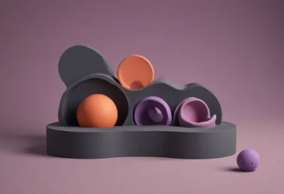 A rounded toy shape-sorter box with three differently shaped cutout holes
