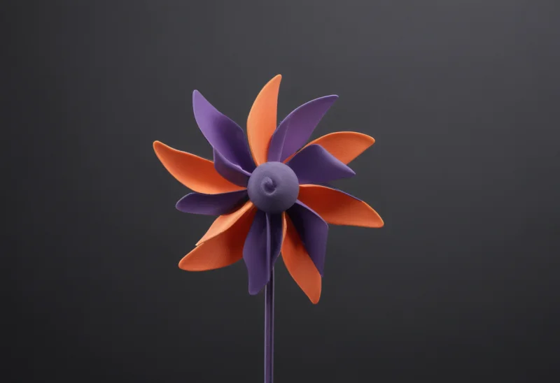 A pinwheel on a slender stick, its vanes caught mid-turn