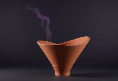 A matte-clay funnel standing upright, its wide mouth tapering to a single narrow spout