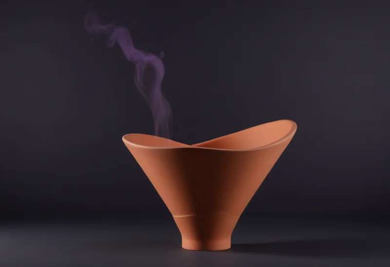 A matte-clay funnel standing upright, its wide mouth tapering to a single narrow spout
