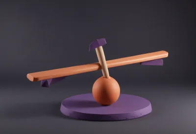 A wooden see-saw plank balanced on a round fulcrum, one end dipped low and the other raised