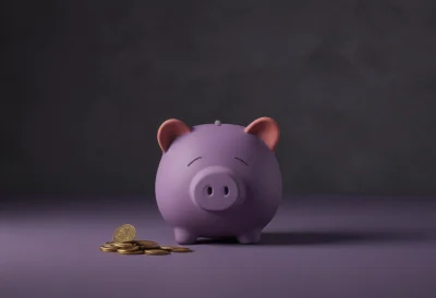 A rounded clay piggy bank with a small pile of coins beside it