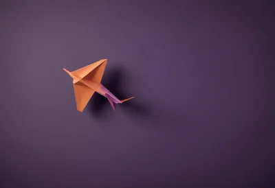 A paper airplane caught in mid-glide, nose tilted slightly upward