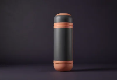 A cylindrical pneumatic-tube carrier capsule with rounded brass end caps standing upright on a plain surface