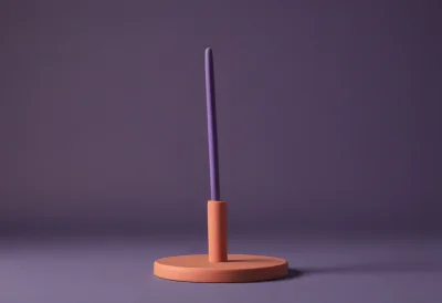 A matte-clay conductor's baton resting on a small round stand